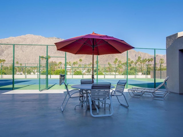 view of patio / terrace featuring tennis court and a mountain view