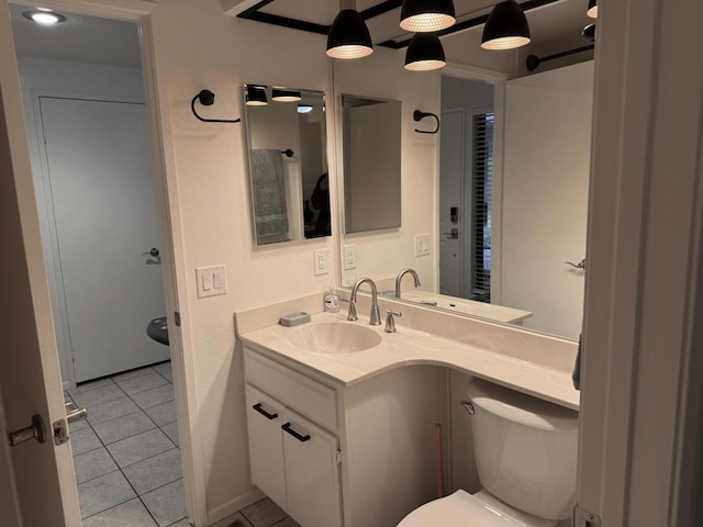 bathroom featuring toilet, tile patterned flooring, and vanity