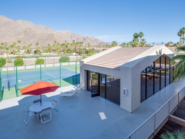 view of patio / terrace featuring tennis court and a mountain view