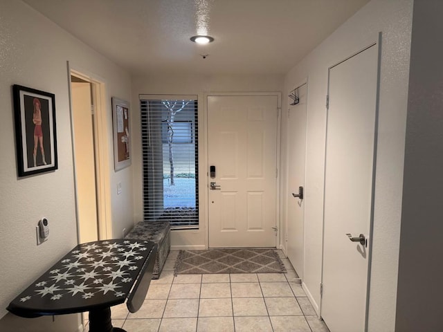 doorway to outside with light tile patterned flooring