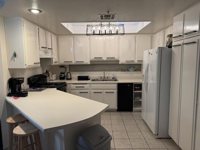 kitchen with black appliances, white cabinetry, sink, and light tile patterned floors