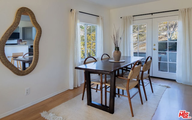 dining room with light wood-type flooring, french doors, and plenty of natural light