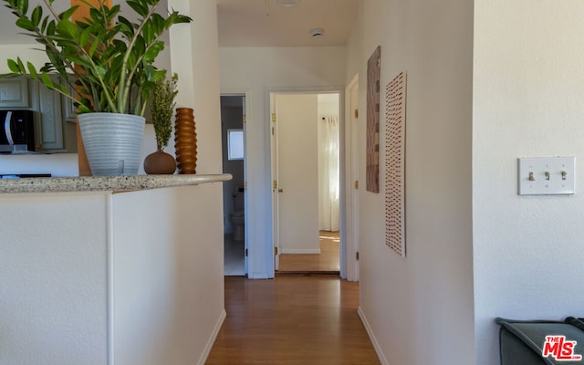 corridor with dark hardwood / wood-style flooring