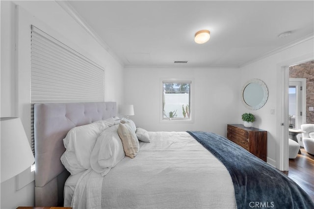 bedroom with ornamental molding and hardwood / wood-style floors