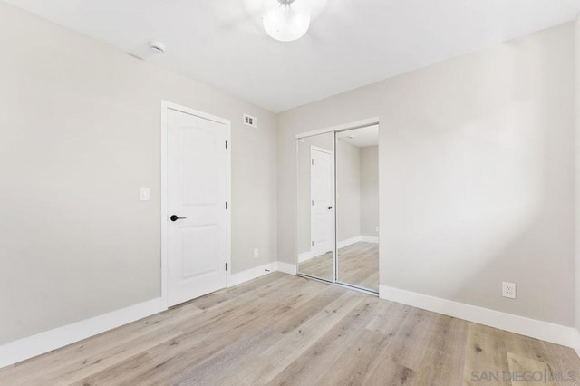 unfurnished bedroom featuring a closet and light hardwood / wood-style floors