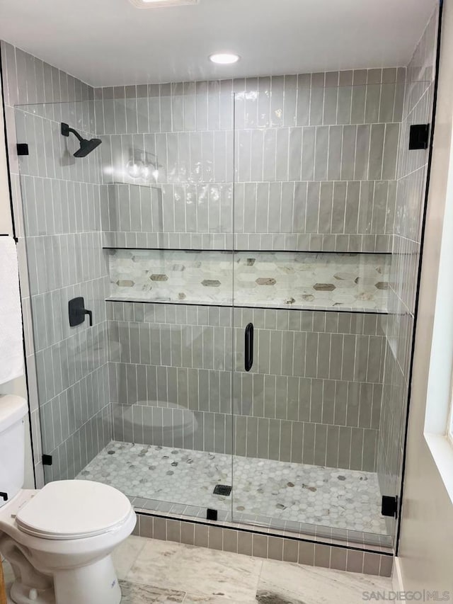 bathroom featuring toilet, tile patterned floors, and walk in shower