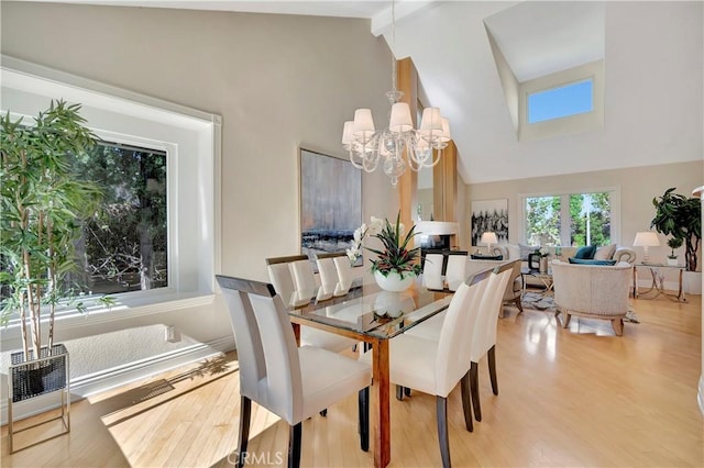 dining area featuring an inviting chandelier, lofted ceiling with beams, and light hardwood / wood-style flooring