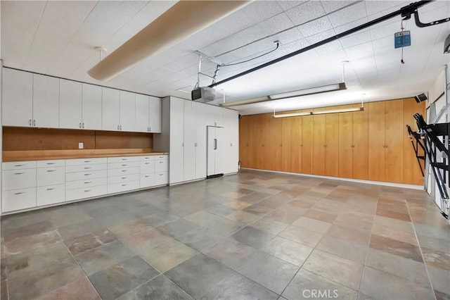 garage featuring a garage door opener and wood walls