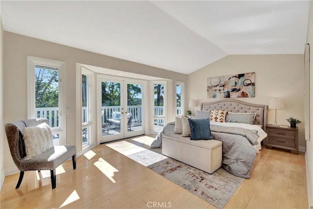 bedroom with access to outside, vaulted ceiling, french doors, and light hardwood / wood-style flooring