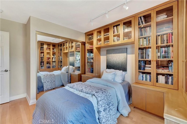 bedroom featuring rail lighting and light hardwood / wood-style floors