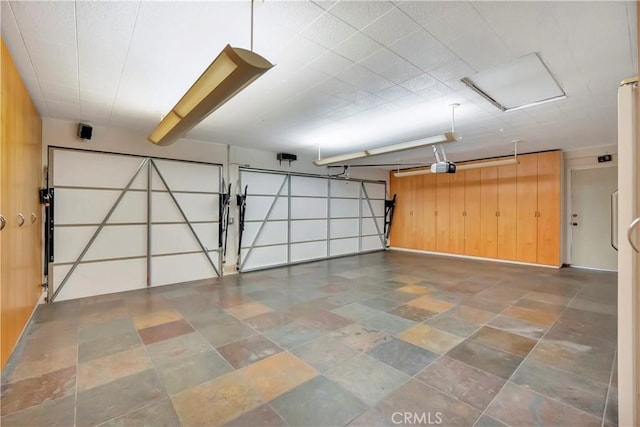 garage featuring a garage door opener and wood walls