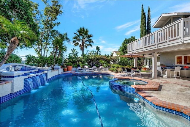 view of swimming pool featuring pool water feature, exterior bar, an in ground hot tub, and a patio