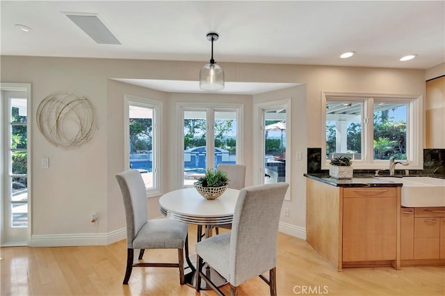 dining space featuring light wood-type flooring and sink