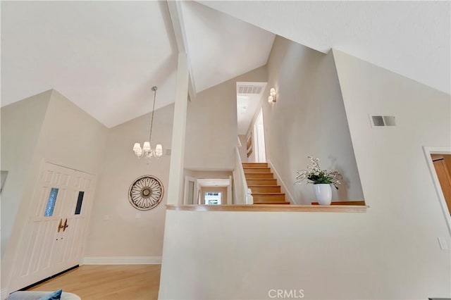 foyer featuring a notable chandelier, high vaulted ceiling, and light hardwood / wood-style floors