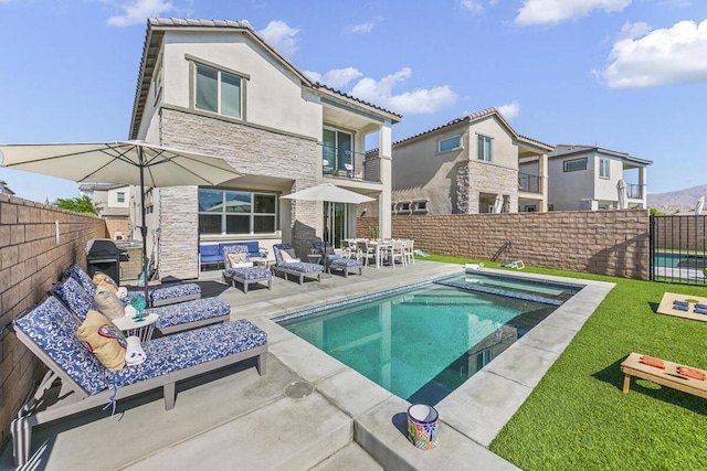 back of house with a pool with hot tub, a patio area, and outdoor lounge area