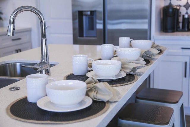 details with stainless steel fridge with ice dispenser and white cabinetry