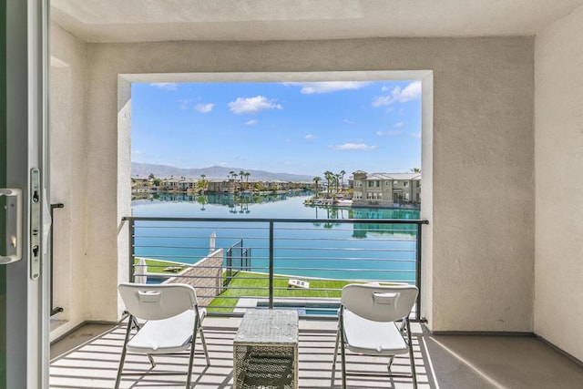 balcony featuring a water and mountain view