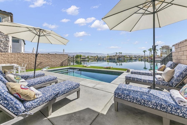 view of pool featuring a patio area and a water view