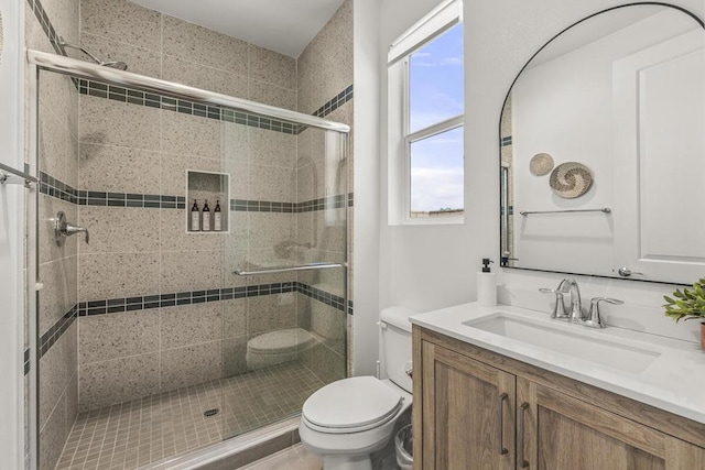 bathroom featuring toilet, walk in shower, and vanity