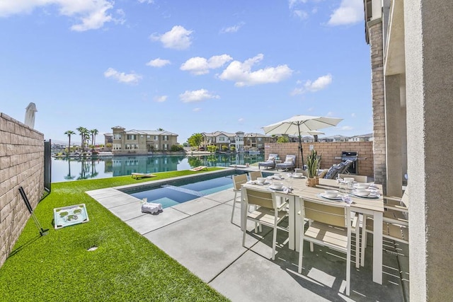 view of pool featuring a patio, a water view, and a yard