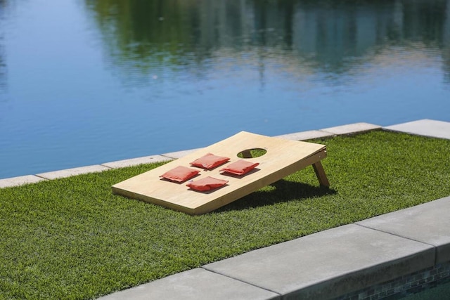 view of dock featuring a lawn and a water view