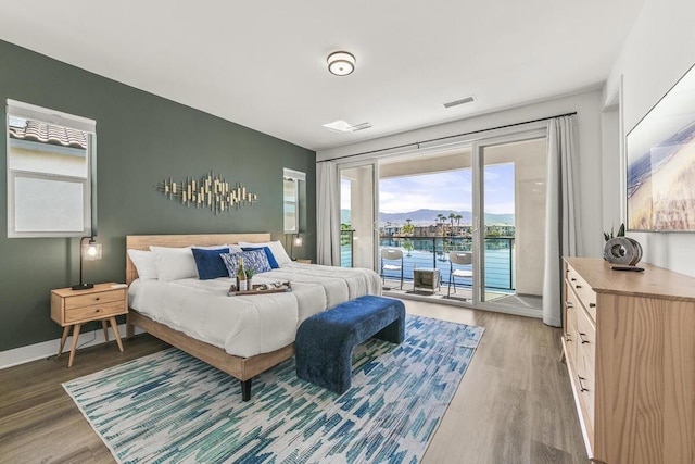 bedroom featuring access to exterior and hardwood / wood-style floors