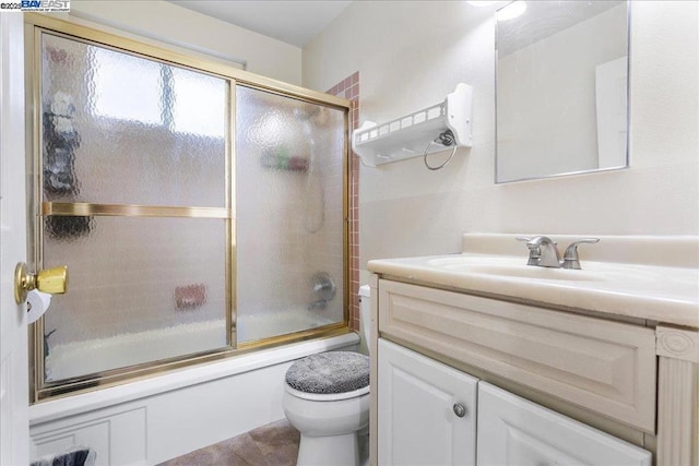 full bathroom with enclosed tub / shower combo, tile patterned flooring, vanity, and toilet