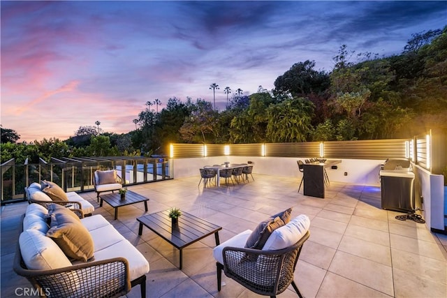 patio terrace at dusk featuring an outdoor living space with a fire pit