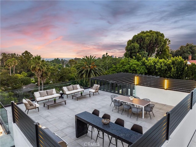 patio terrace at dusk with an outdoor living space with a fire pit