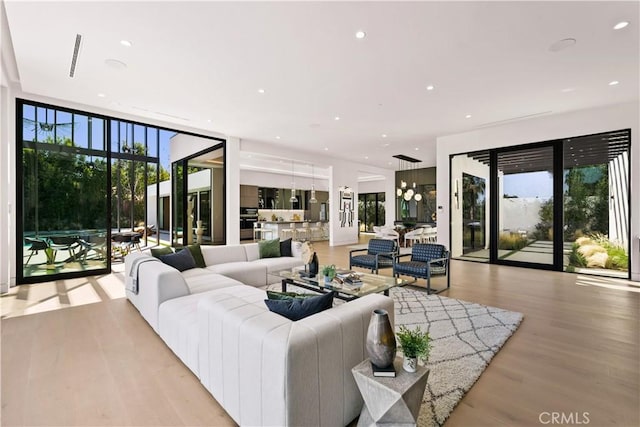 living room with a wall of windows and light hardwood / wood-style floors