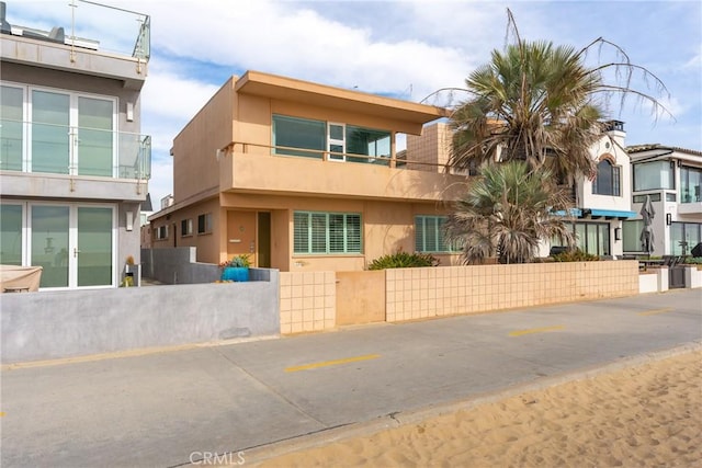 view of front of property featuring stucco siding and fence