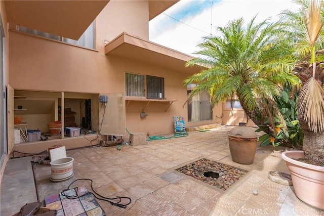 back of property with a patio and stucco siding