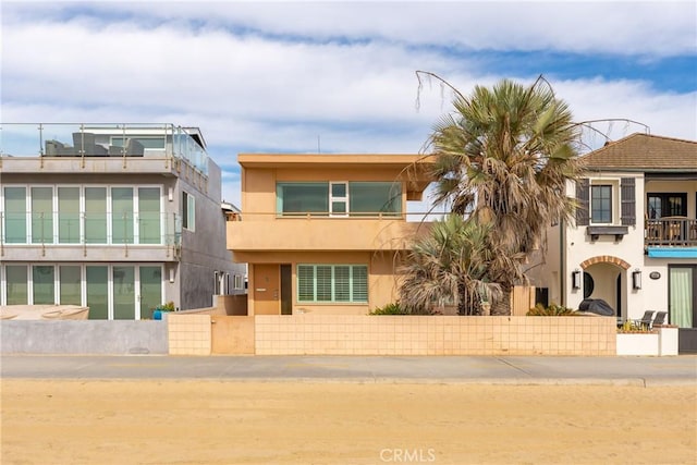 view of front of home with stucco siding and a balcony