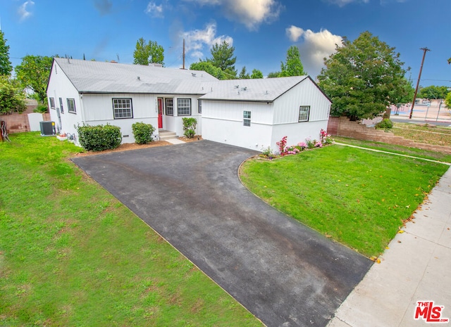 view of front of property with a front yard and central AC unit