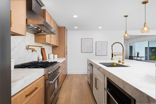 kitchen with appliances with stainless steel finishes, light brown cabinetry, light stone counters, decorative light fixtures, and exhaust hood