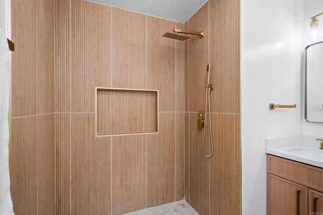 bathroom featuring tiled shower and vanity