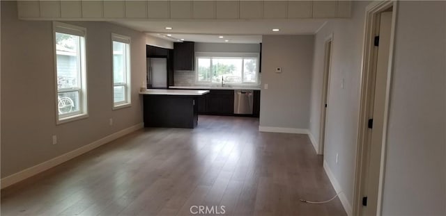 kitchen with tasteful backsplash, appliances with stainless steel finishes, and light wood-type flooring