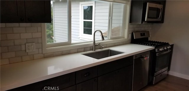 kitchen with sink, decorative backsplash, dark wood-type flooring, and stainless steel appliances