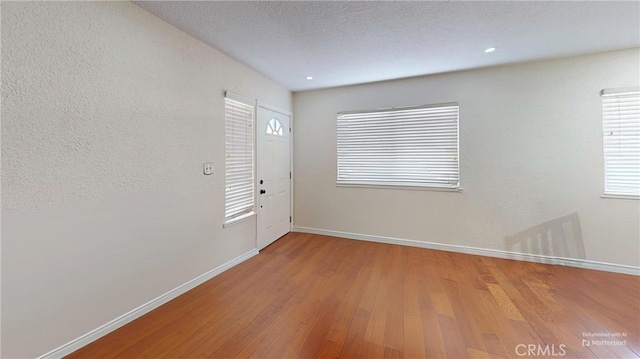 interior space featuring wood-type flooring and a textured ceiling