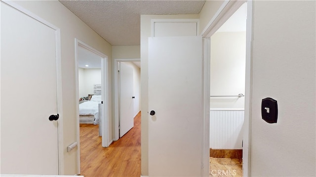 hallway featuring a textured ceiling and light hardwood / wood-style floors