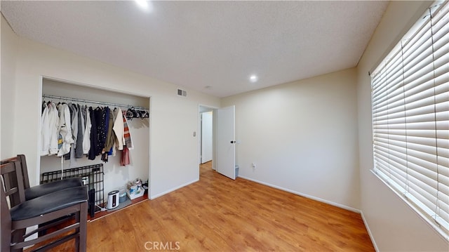 bedroom featuring a textured ceiling, a closet, and hardwood / wood-style flooring