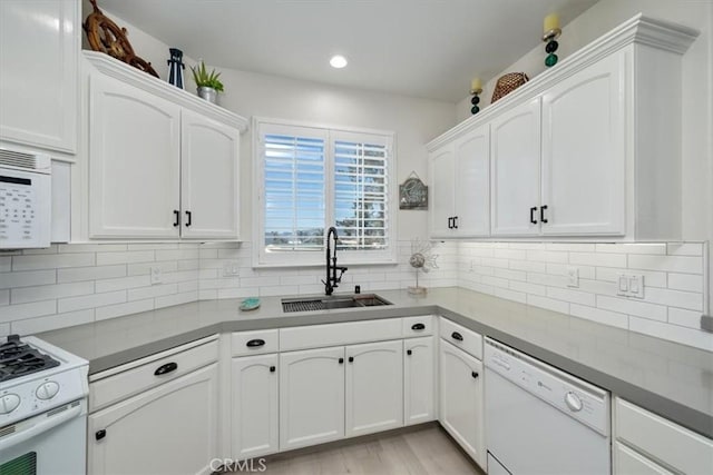 kitchen featuring white cabinetry, sink, and white appliances