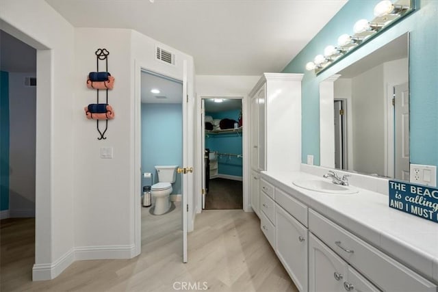 bathroom with vanity, wood-type flooring, and toilet