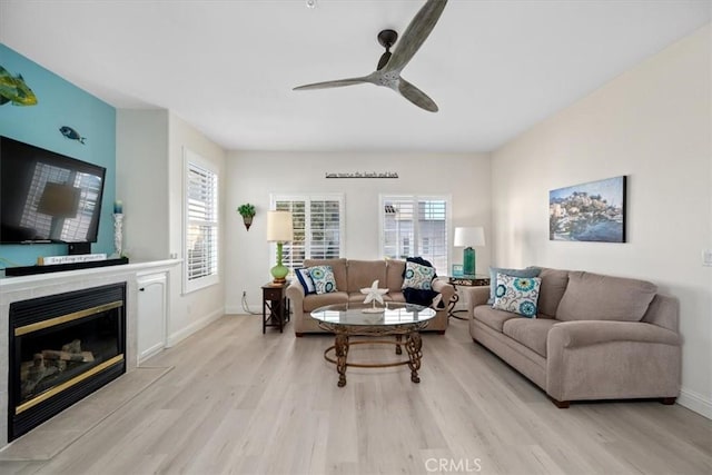 living room featuring ceiling fan and light hardwood / wood-style flooring