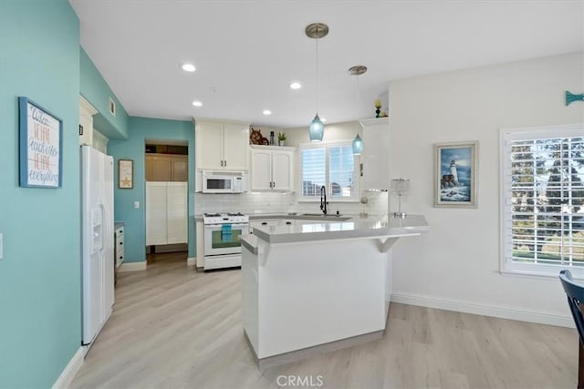 kitchen featuring pendant lighting, white appliances, backsplash, white cabinets, and kitchen peninsula