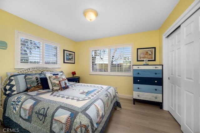 bedroom with light hardwood / wood-style floors and a closet