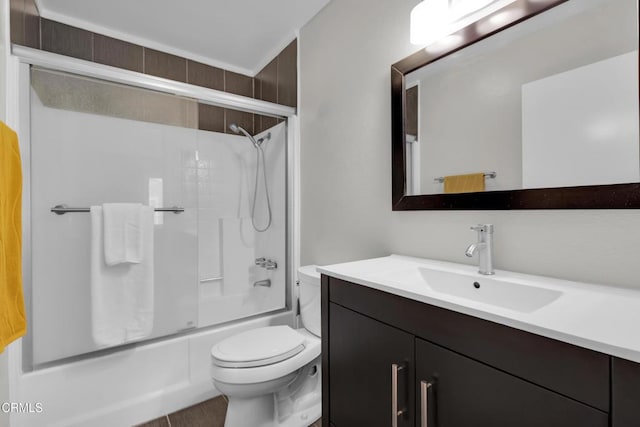 full bathroom featuring combined bath / shower with glass door, vanity, and toilet