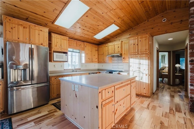 kitchen featuring wooden ceiling, white microwave, a center island, vaulted ceiling with skylight, and stainless steel refrigerator with ice dispenser