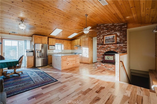 kitchen with a healthy amount of sunlight, white microwave, stainless steel fridge with ice dispenser, lofted ceiling, and wooden ceiling