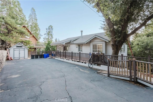 exterior space with a wooden deck and a storage unit